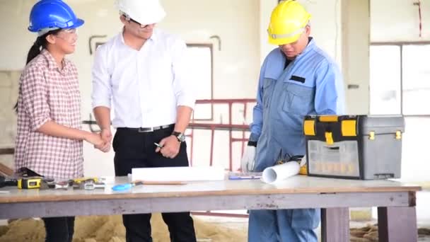 Construction engineer teamwork discuss meeting together with Safety Suit Trust Team Holding White Yellow Safety hard hat Security Equipment on Construction Site. Hardhat Protect Head for Civil Construction Engineer Concept - Footage, Video