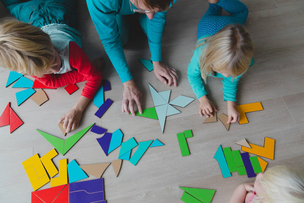 teacher and kids play with puzzle, doing tangram - Zdjęcie, obraz