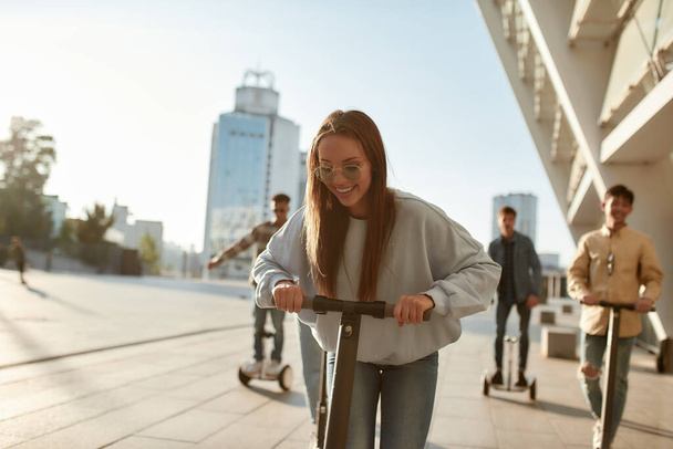 Get better rides. A group of friends using kick scooters and segways on a sunny day - 写真・画像