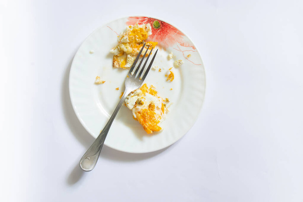 smažené vejce v talířích s vidličkou zbytkové jídlo na izolovaném pozadí - Fotografie, Obrázek