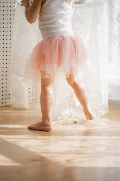  little girl in a pink skirt, beautiful sunlight at home - Foto, immagini