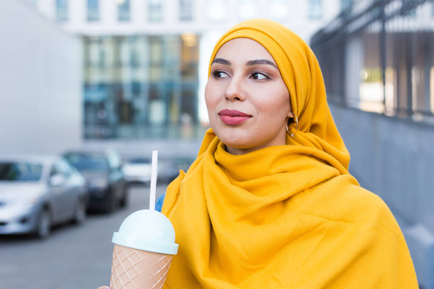 Молодая арабская мусульманка, наслаждающаяся коктейлем на открытом воздухе
. - Фото, изображение
