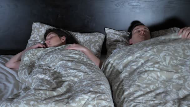 junges Paar geht ins Bett. Tauziehen um Decken - Filmmaterial, Video