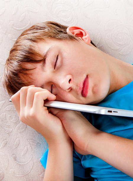 Tired Teenager sleep with a Tablet Computer on the Sofa - Fotoğraf, Görsel