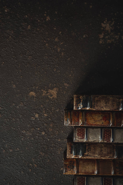 Régi vágású lapos feküdt egy halom antik bőr kötött könyvek ellen sötét háttér - Fotó, kép