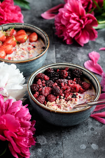 Oatmeal with fruits and berries, breakfast with beautiful peons - Fotó, kép