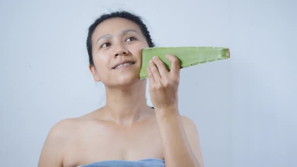 Mouvement lent des femmes utilisant la peau de traitement de l'aloe vera sur fond blanc
 - Séquence, vidéo