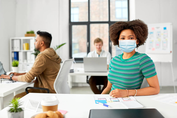african american woman in medical mask at office - Foto, immagini