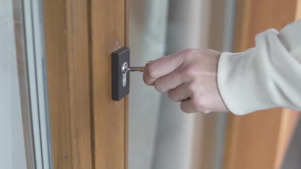 Una mujer inserta una llave en un ojo de cerradura
 - Metraje, vídeo