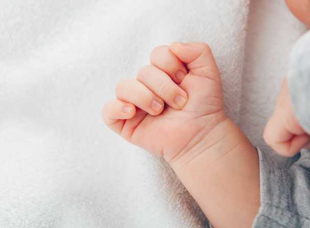 Newborn babys hand close-up on white blanket  - Foto, Bild