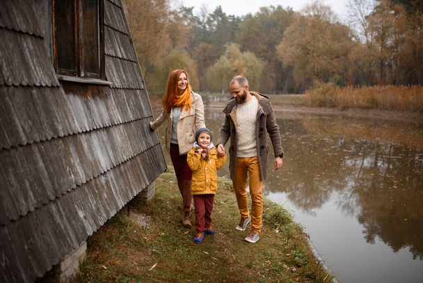 Onnellinen perhe. Isä, äiti ja poika hauskaa ja leikkii syksyllä luonto
. - Valokuva, kuva