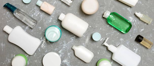 プラスチック製のボディケアボトルのグループフラットは、あなたが設計するための緑の背景の空のスペースに化粧品と組成物を敷設。白い化粧品の容器のセット、コピースペースが付いている上の眺め. - 写真・画像