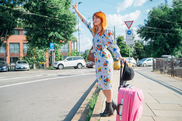 Mulher adulta média outdor levantando a mão perguntando táxi - turismo, transporte, conceito commuter
 - Foto, Imagem