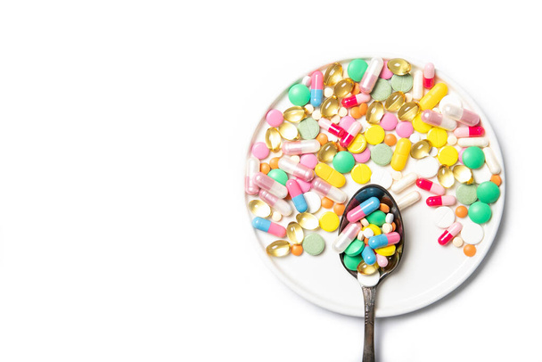Spoon with multi-colored pills on a white background. Place for text. The medicine - Photo, Image