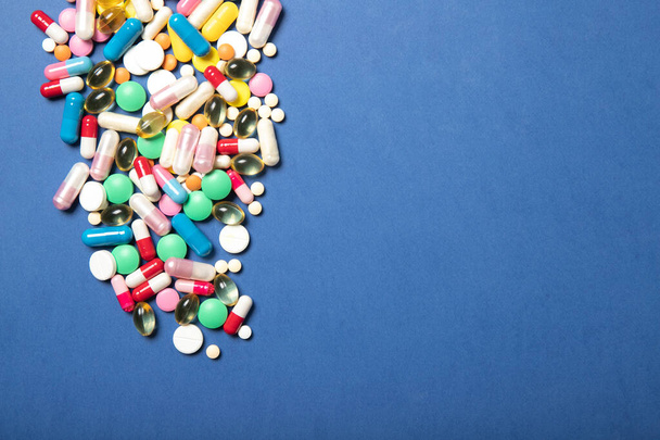 Pills and capsules on a blue background.Concept of medicine and health. - 写真・画像