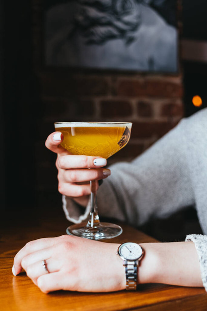 person hand holding yellow malt beer glass on pub background - Fotoğraf, Görsel