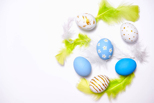 Kreative Osterferien Layout Eier gefärbt handgemachte Farbe mit Feder auf weißem Hintergrund übermalt.Saisonale flache Lagekonzept. - Foto, Bild