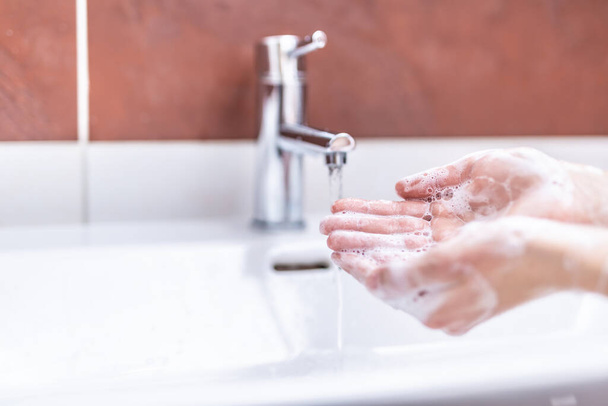 Kézmosás vízzel és folyékony szappannal a fürdőszobában. Higiéniai antivírus-koncepció - Fotó, kép