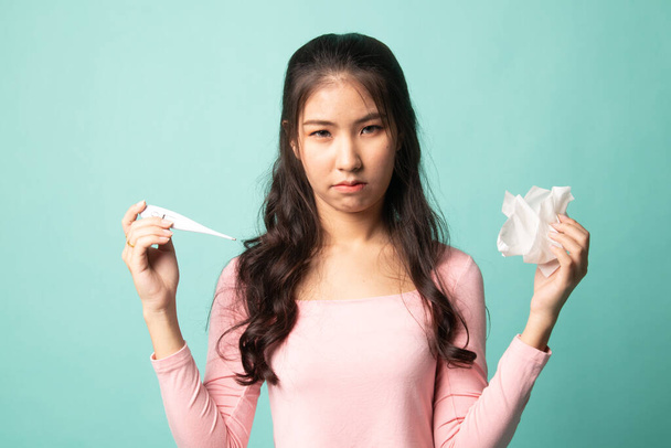 Joven mujer asiática se enfermó y la gripe en cyan fondo
 - Foto, Imagen