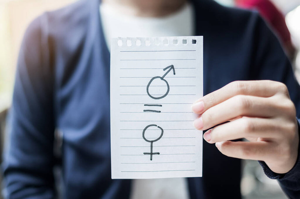 vrouw hand vasthouden Papier nota met gelijk teken tussen man en vrouw symbool. Gendergelijkheid, Internationale Vrouwendag en Mensenrechten - Foto, afbeelding