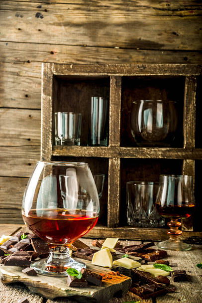 Mocny drink alkoholowy. Szklanka brandy, whisky lub koniaku na drewnianym stole - Zdjęcie, obraz