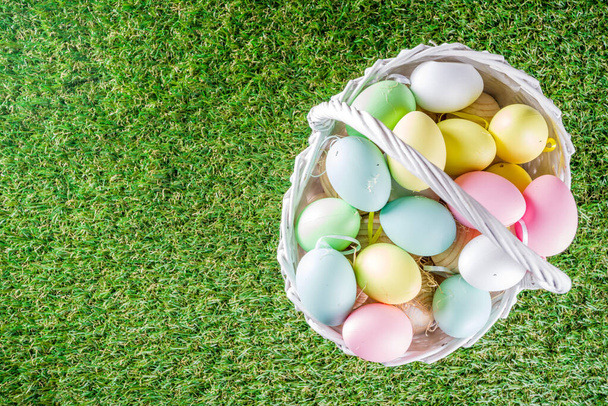 Colorful pastel Easter eggs on green and wooden garden terrace.  Funny spring decoration. Happy Easter greeting card background.  - 写真・画像