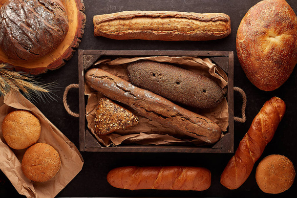 Freshly baked delicious bread on a rustic wooden worktop with copy space, healthy eating concept, flat lay - Foto, Imagen