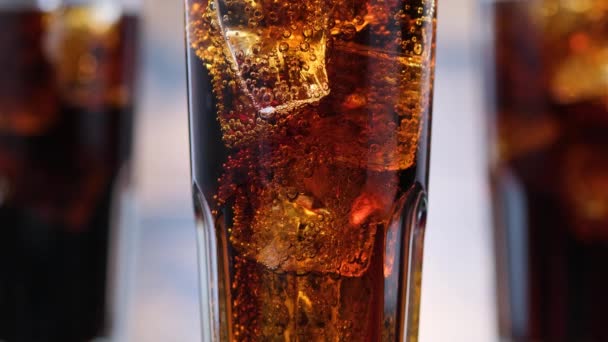 Burbujas de primer plano en vidrio con cola y cubitos de hielo. Burbujas se levantan de bebida gaseosa. Macro
 - Metraje, vídeo