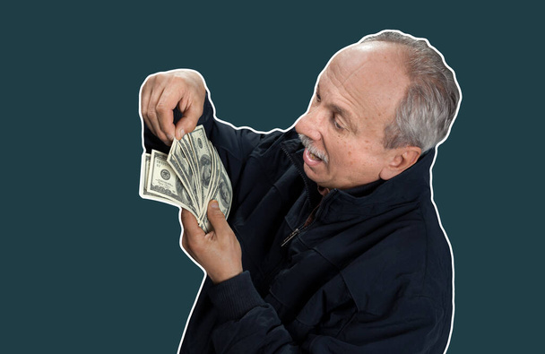 Starší pán drží hromadu peněz. Portrét vzrušeného starého muže. Šťastný stařík držící dolarové bankovky. Koláž ve stylu časopisu s kopírovacím prostorem - Fotografie, Obrázek