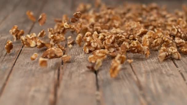 SLOW MOTION, DOF: Delicious organic walnut kernels roll down the wooden table. - Imágenes, Vídeo