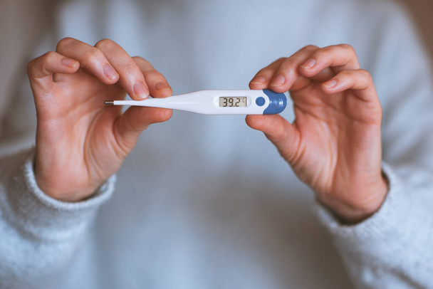 Woman holding thermometer with high temperature closeup. Illness concept.  - Foto, afbeelding