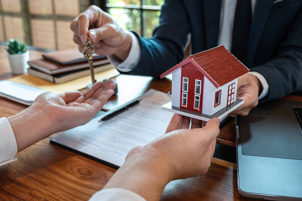 Ingatlanügynök bemutatja lakáshitel és küldje el a kulcsokat az ügyfélnek aláírása után szerződést vásárolni ház jóváhagyott ingatlan igénylőlap, Insurance Home koncepció. - Fotó, kép