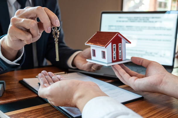 家を購入するための売買契約、顧客は承認されたフォームで家を購入する契約を締結した後、住宅ローンを購入し、エージェントから鍵を与えるお金を送る、保険とホームコンセプト. - 写真・画像