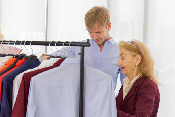 Older female designers recommend men's suits in sewing shops - Foto, Bild