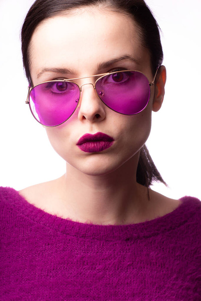 girl in a purple sweater, purple glasses with purple lipstick on her lips - Foto, Imagen