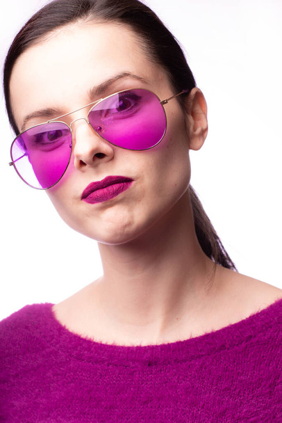 girl in a purple sweater, purple glasses with purple lipstick on her lips - Foto, Bild