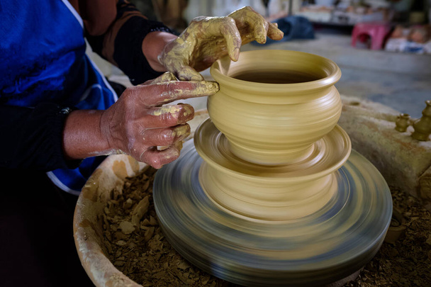 Detailní záběr místní ženy demonstruje na výrobu tradiční hliněné sklenice Labu Sayong nebo Essence Jar of Sayong uvnitř dílny v Kuala Kangsar, Perak, Malajsie. Tradiční koncept hrnčířství. - Fotografie, Obrázek