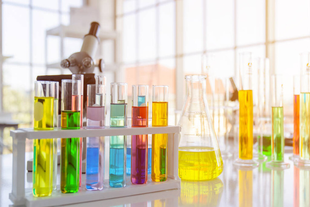 Φιάλες αντιδραστηρίου χημικών, φιάλες επιστημονικών πειραμάτων διαφόρων σχημάτων, μεγεθών και μικροσκοπίων στο τραπέζι - Φωτογραφία, εικόνα
