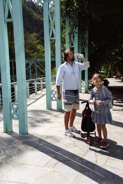 Dad and daughter walking around the city and drinking mineral water - Fotografie, Obrázek