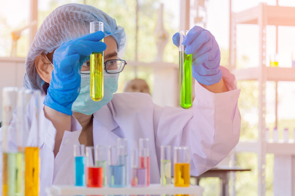 Uma cientista asiática está pesquisando uma fórmula química em um laboratório
. - Foto, Imagem