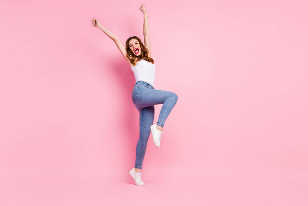 Full size photo of ecstatic cheerful redhead girl enjoy sport contest win raise fists scream yeah wear stylish trendy tank-top sneakers isolated over pink color background - Fotografie, Obrázek