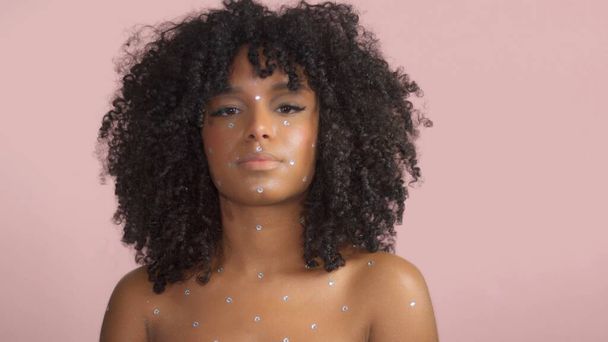 混合レース黒女性とともに巻き毛で覆われた結晶化粧上のピンクの背景でスタジオ - 写真・画像