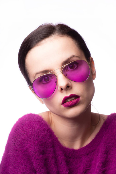 girl in a purple sweater, purple glasses with purple lipstick on her lips - Fotoğraf, Görsel