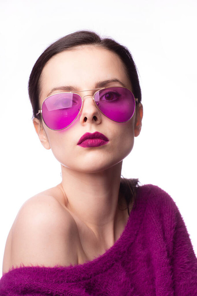 girl in a purple sweater, purple glasses with purple lipstick on her lips - 写真・画像