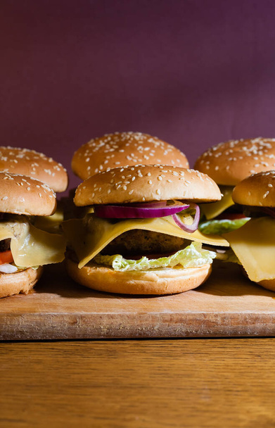 Cheeseburgers faits maison sur un plateau en bois
. - Photo, image