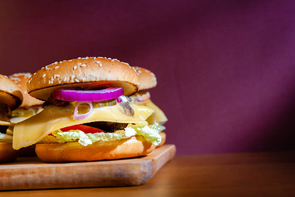 Domácí cheeseburgery na dřevěném podnosu. - Fotografie, Obrázek
