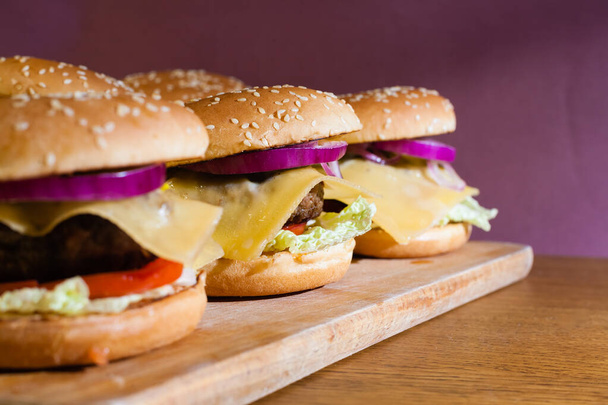 Homemade cheeseburgers on a wooden tray. - Fotografie, Obrázek