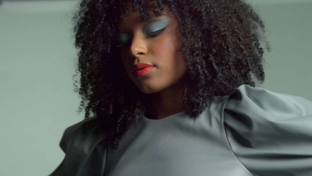 femme de race mixte avec de gros cheveux bouclés en cuir robe de mode en studio
 - Photo, image