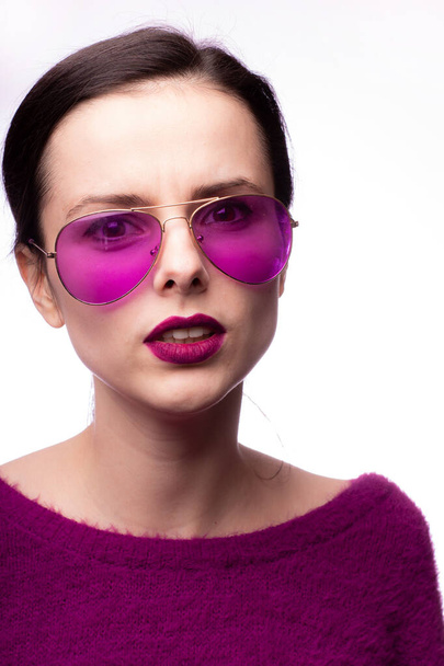 girl in a purple sweater, purple glasses with purple lipstick on her lips - Фото, изображение