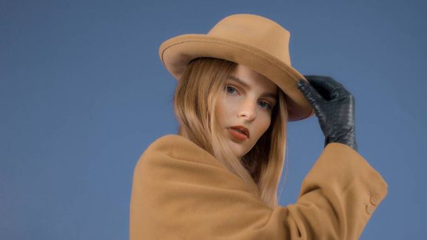 Модный редакционный портрет блондинки модели носит яркое закрытие на красочном фоне в студии
 - Фото, изображение